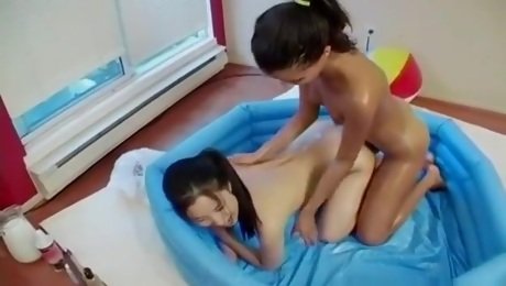 Two lesbian Asians having fun in a kiddy pool
