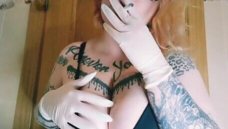 Girl smokes a cigarette and plays with her tits with gloves